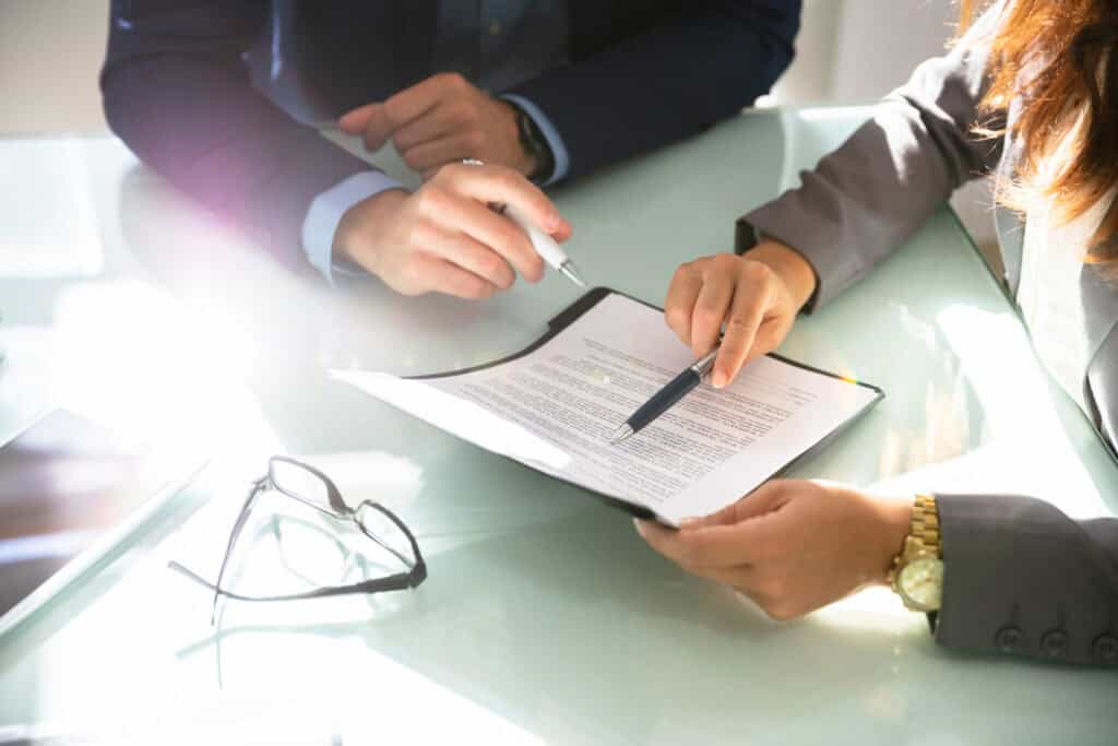 Financial Settlement Review: Businesspeople analyze document at glass desk, Perth lawyers, Estate Planning, Wills, Probate, Letters of Admin