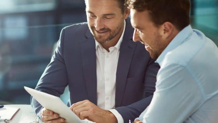 Perth Lawyers' meeting: Two professionals review 'Disclaiming a Gift' on a tablet, discussing estate & commercial law at Clairs Keeley Lawyers.