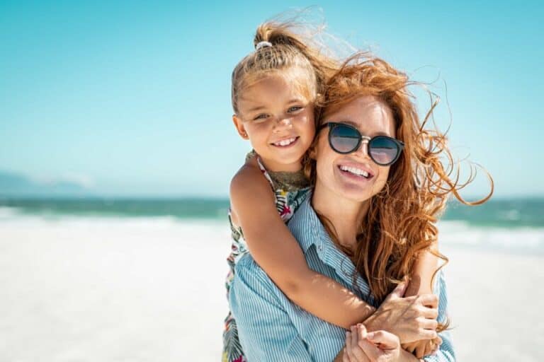 Happy mother and daughter embrace on a beach in Perth, symbolizing family support. Clairs Keeley Lawyers offer child support legal services.